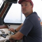 John Stanford at the helm